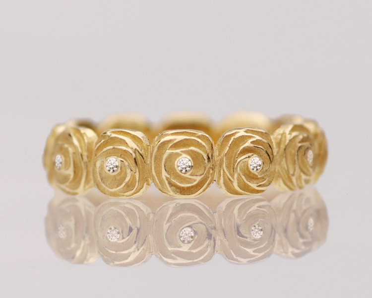 Artisan carved sculptural rose flower and diamond wedding ring. Unique floral design eternity band cast in 14K yellow gold.