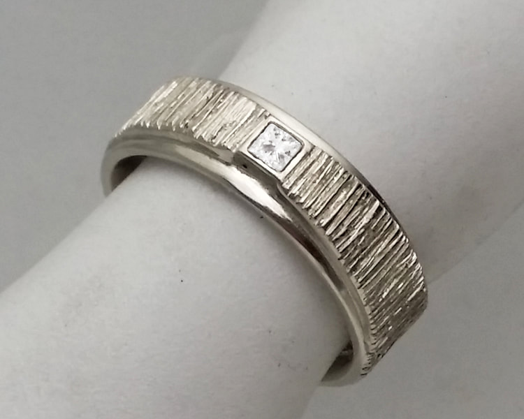 Men's modern diamond ring with a square, princess cut diamond and organic geometric design elements, cast in 14K white gold.
